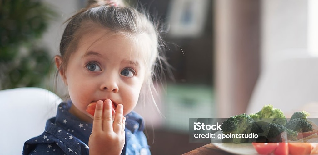Cute girl eating a strawberry