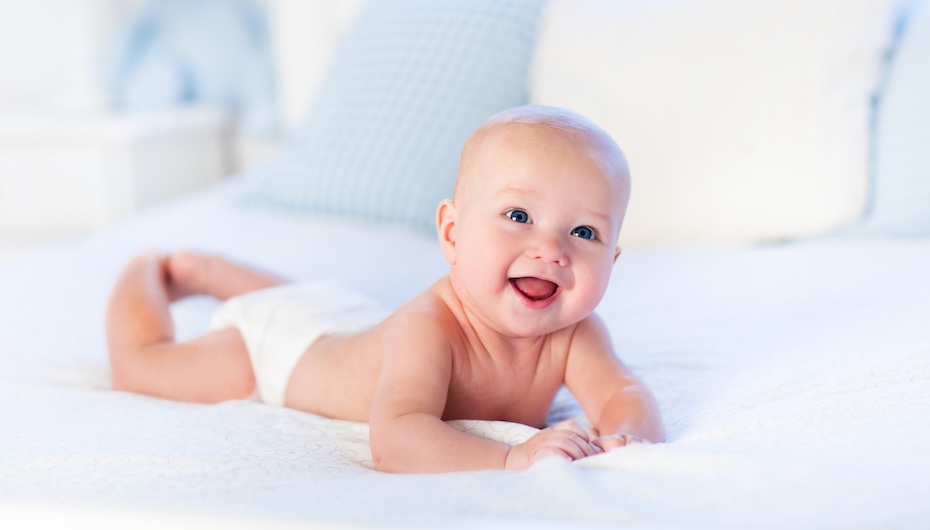 Baby boy on white bed